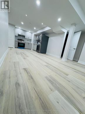 Oakville (Go Glenorchy) apartment for rent - A spacious room with wooden flooring and white walls.