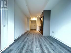 Toronto (Waterfront Communities) condo for rent - A long hallway with wood flooring and white walls.