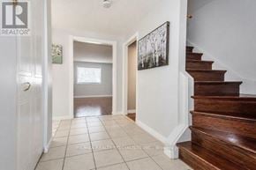 Cambridge apartment for rent - A hallway with a wooden staircase and a white door.