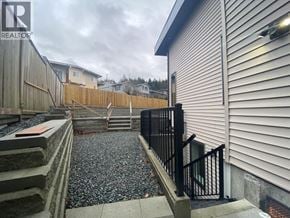 Burnaby apartment for rent - A gravel area in front of a house with a metal railing.