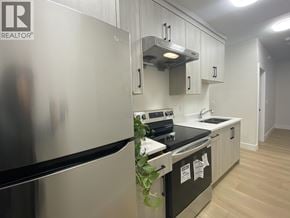Burnaby apartment for rent - A kitchen with a stainless steel refrigerator and black oven.