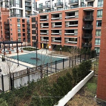 Toronto (Yorkdale-Glen Park) condo for rent - A pool surrounded by a black fence in front of a red brick building.
