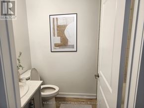 Lincoln (Lincoln Lake) condo for rent - A bathroom with a toilet, sink, and a picture of a boot hanging on the wall.