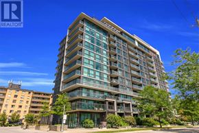 Toronto (West Humber-Clairville) condo for rent - A tall building with many windows and balconies is surrounded by greenery and other buildings.