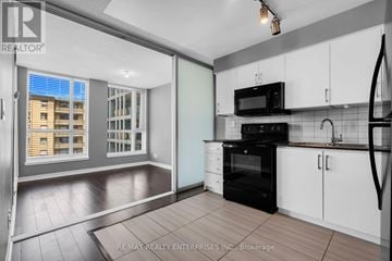 Toronto (West Humber-Clairville) condo for rent - A kitchen with white cabinets and a black oven.