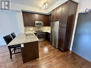 Mississauga (Erin Mills) condo for rent - A kitchen with brown cabinets and a granite countertop.