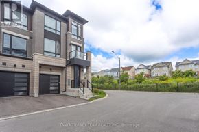 Whitby (Brooklin) townhouse for rent - A modern two-story building with a garage is surrounded by a fence and other houses.