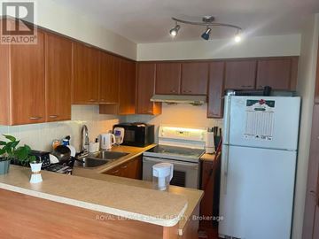 Toronto (Woburn) condo for rent - A kitchen with wooden cabinets and a white fridge.