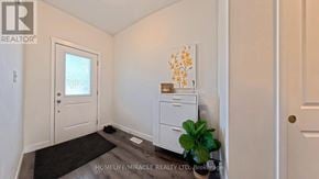 Norfolk (Simcoe) townhouse for rent - A white door with a window in the background and a plant on the floor.