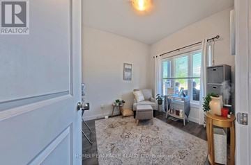 Norfolk (Simcoe) townhouse for rent - A living room with a grey couch and a white rug.