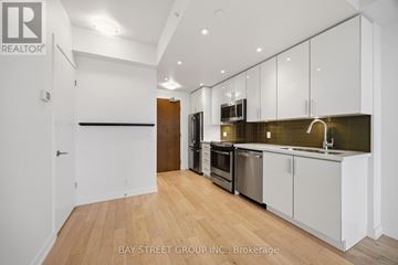 Toronto (Mimico) condo for rent - A kitchen with white cabinets and a wooden floor.