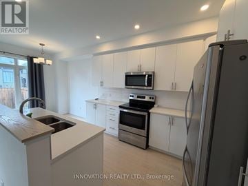 Ottawa townhouse for rent - A kitchen with white cabinets and a wooden countertop.