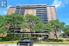 Toronto (Eglinton East) condo for rent - A tall apartment building with a car parked in front of it.