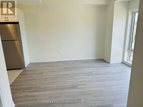 Toronto (Malvern) townhouse for rent - A room with a wooden floor and a refrigerator.