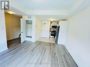 Toronto (Malvern) townhouse for rent - A room with a wooden floor and white walls, with a door open to another room.