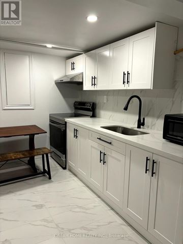 Toronto (Cabbagetown-South St. James Town) apartment for rent - A kitchen with white cabinets and a marble countertop.