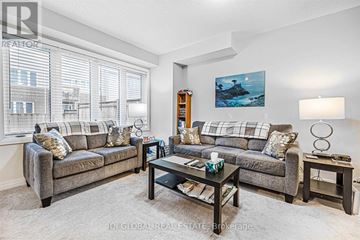 Lincoln (Beamsville) townhouse for rent - A living room with a grey couch, a coffee table, and a painting on the wall.