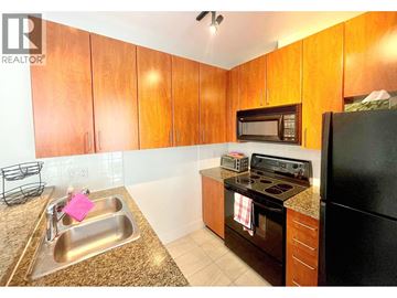 Vancouver apartment for rent - A kitchen with wooden cabinets and black appliances.