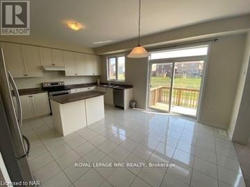 Niagara Falls (Brown) apartment for rent - A kitchen with white cabinets and a tiled floor.