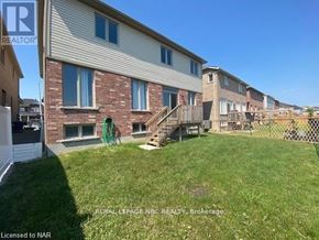 Niagara Falls (Brown) apartment for rent - A grassy yard in front of a building with a sign that says "REALTOR".