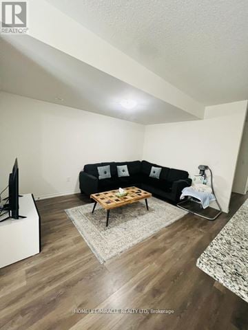 Toronto (Rouge) townhouse for rent - A living room with a black couch and a wooden coffee table.