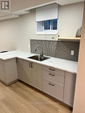 Milton (De Dempsey) apartment for rent - A kitchen with white cabinets and a grey backsplash.