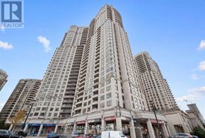 Mississauga (City Centre) condo for rent - A tall building with many windows is in the foreground.