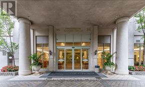 Mississauga (City Centre) condo for rent - The front of a building with a large glass door and a sign that reads "Kingsbridge Garden Circle".