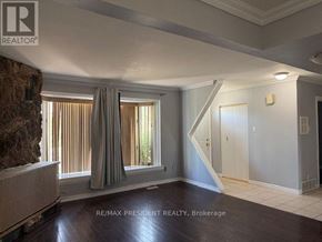 Brampton (Avondale) apartment for rent - A room with a stone wall and a window with curtains.
