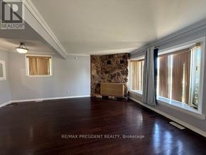Brampton (Avondale) apartment for rent - A large empty room with a wooden floor and a patterned wallpaper on one wall.