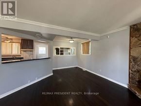 Brampton (Avondale) apartment for rent - A spacious room with a kitchen area in the background and a large empty space in the foreground.