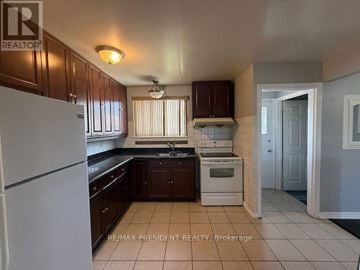 Brampton (Avondale) apartment for rent - A kitchen with white appliances and brown cabinets.