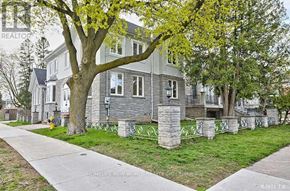 Toronto (Willowdale East) apartment for rent - A tree with green leaves is in front of a grey house.