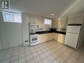 Toronto (Willowdale East) apartment for rent - A white kitchen with tile flooring and white appliances.