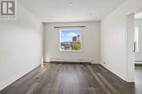 St. Catharines (E. Chester) apartment for rent - A spacious room with a window overlooking a cityscape.