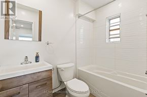 St. Catharines (E. Chester) apartment for rent - A white bathroom with a toilet, sink, and bathtub.