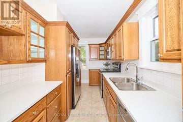 Niagara Falls (Cherrywood) apartment for rent - A kitchen with wooden cabinets and a black refrigerator.