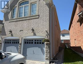 Oshawa (Taunton) apartment for rent - A house with a stone wall and a garage door.