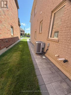 Oshawa (Taunton) apartment for rent - A brick building with a green lawn in front.