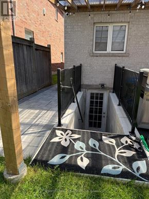 Oshawa (Taunton) apartment for rent - A black and white rug with a flower design is on the ground.