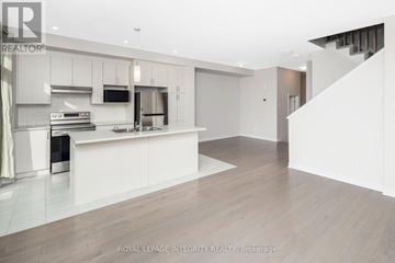 Clarence-Rockland townhouse for rent - A modern kitchen with white cabinets and a wooden floor.