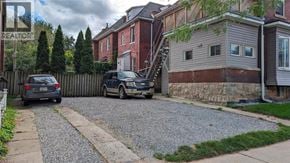 Hamilton apartment for rent - A gravel driveway leads to a house with a car parked on the side.