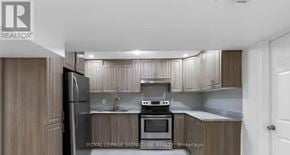 Ajax (Northwest Ajax) apartment for rent - A kitchen with wooden cabinets and a stove top oven.