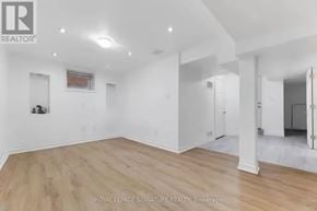 Ajax (Northwest Ajax) apartment for rent - A spacious room with wooden flooring and white walls, with a logo of a realtor in the top left corner.