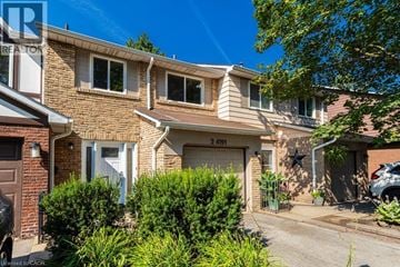 Burlington townhouse for rent - A house with a garage and a car parked in front.