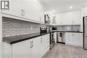 Burlington townhouse for rent - A kitchen with white cabinets and a brick backsplash.