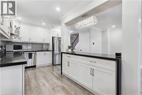 Burlington townhouse for rent - A modern kitchen with white cabinets and a black countertop.