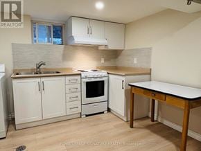 Toronto (East York) apartment for rent - A kitchen with white cabinets and a wooden table.