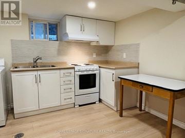 Toronto (East York) apartment for rent - A kitchen with white cabinets and a wooden table.
