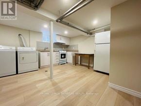 Toronto (East York) apartment for rent - A kitchen area with white appliances and wooden flooring.